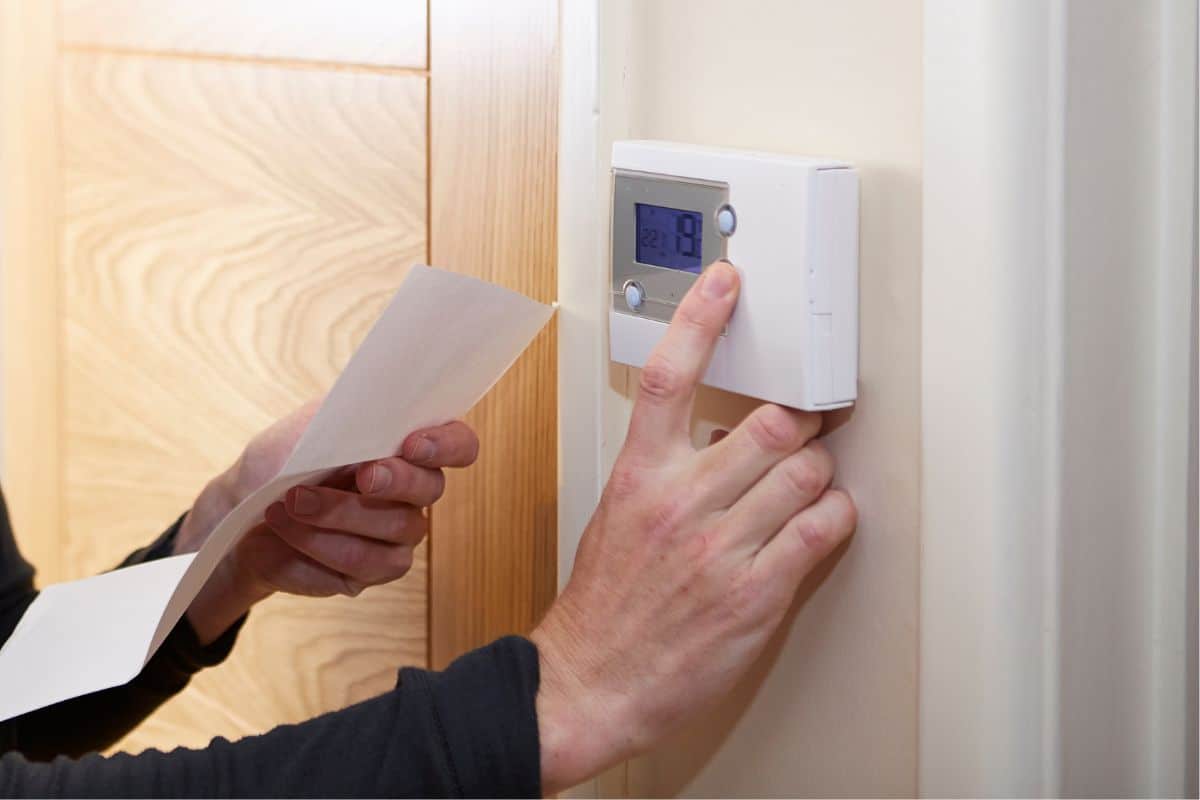 A homeowner checking his home thermostat after the furnace goes out.