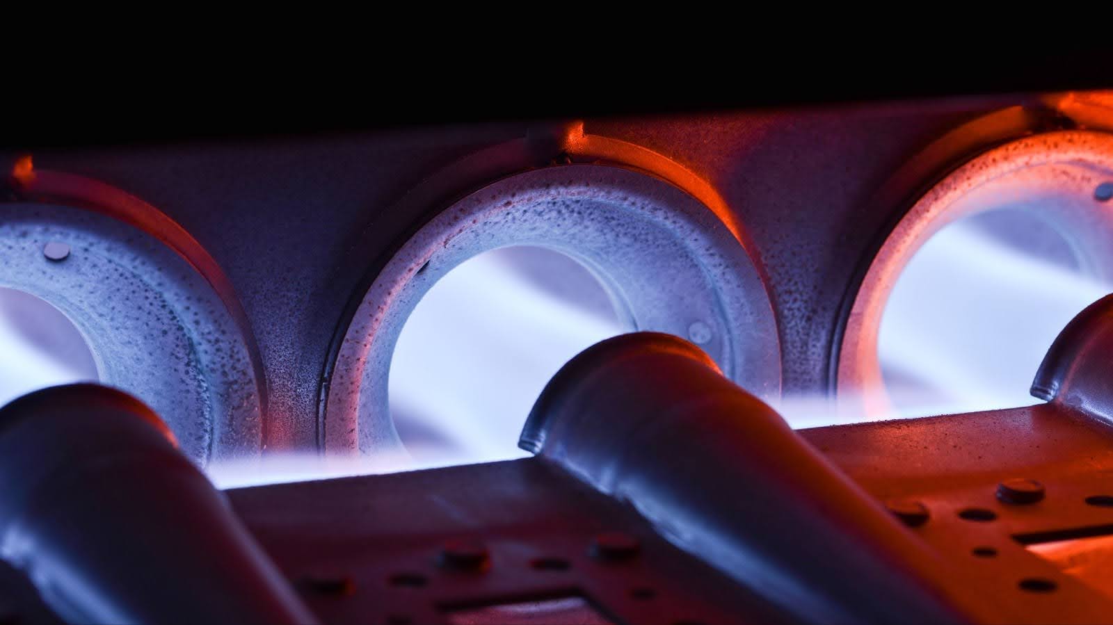 A closeup of an ignited home furnace burner.