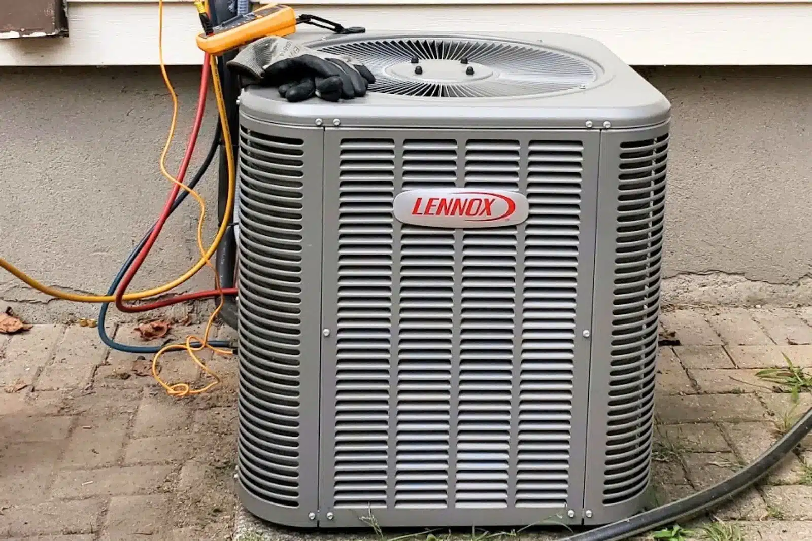 A Lennox AC unit is being maintained professionally.