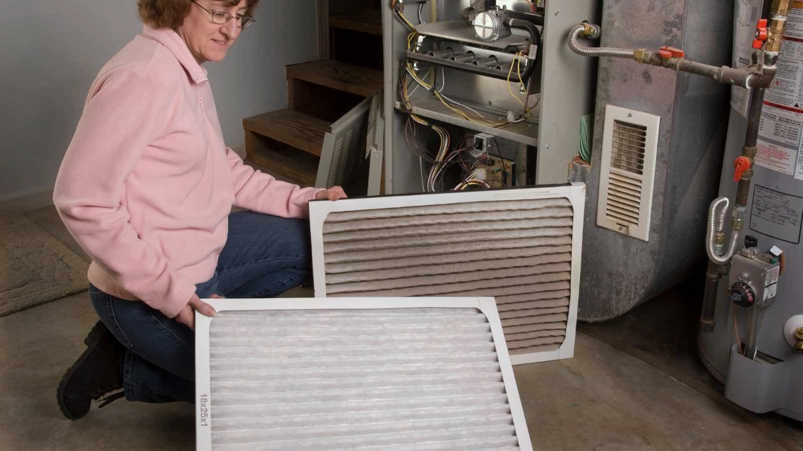A homeowner is replacing a dirty air filter.